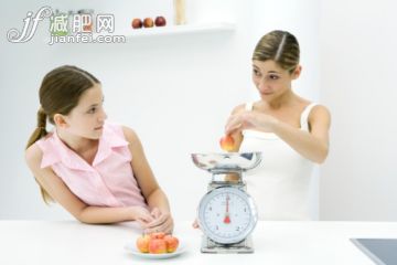 人,衣服,傢具,食品,生活方式_81984181_Mother and daughter weighing apples on scale, looking at each other_創意圖片_Getty Images China