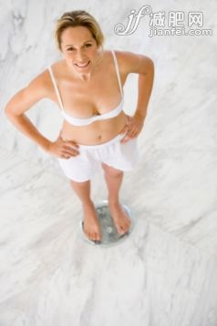 人,半裝,內衣,生活方式,室內_87182740_Young woman in underwear on scales, hands on hips, smiling, portrait, elevated view_創意圖片_Getty Images China