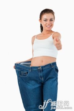 20到24歲,美女,美,肚子,衣服_gic9736780_Portrait of a fit woman wearing too large jeans with the thumb up against a white background_創意圖片_Getty Images China