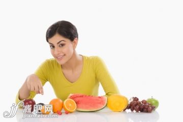 橙色,人,飲食,休閒裝,食品_140667219_Portrait of a woman with a row of assorted fresh fruits_創意圖片_Getty Images China