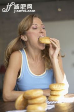 人,食品,生活方式,社會問題,室內_78322080_Woman eating stacks of doughnuts_創意圖片_Getty Images China